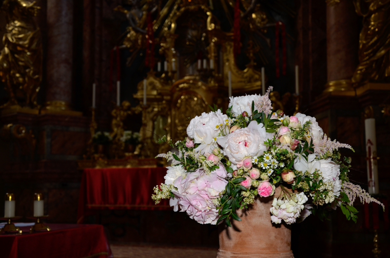 Ein üppiger Blumenstrauß, im Hintergrund ein barocker Kirchenaltar