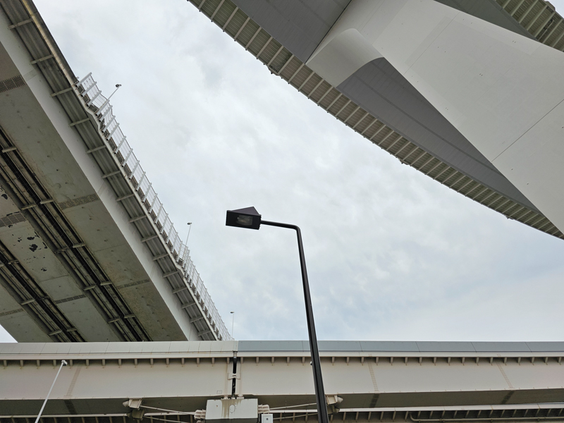 Fahrbahnen von Brücken aus Beton die teilweise bogenförmig übereinander liegen aus der Froschperspektive von unten
